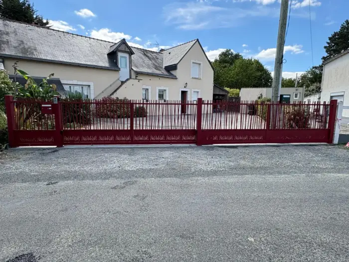 Portail coulissant électrique en aluminium rouge barreaudé, fourni et installé par Anjou Cloture Fermeture.